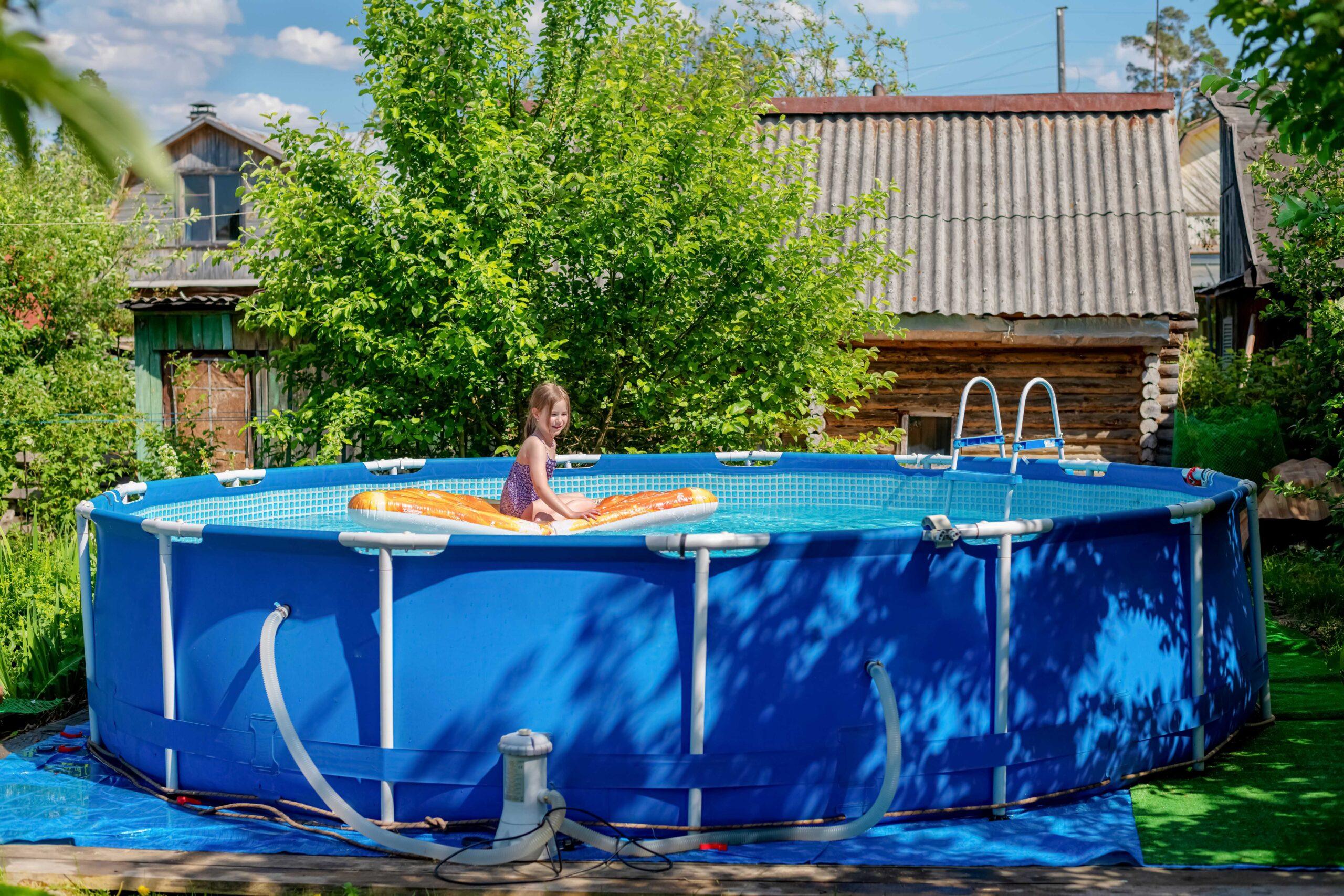 Niedliches kleines Mädchen schwimmt auf einer Strandluftmatratze im Pool.